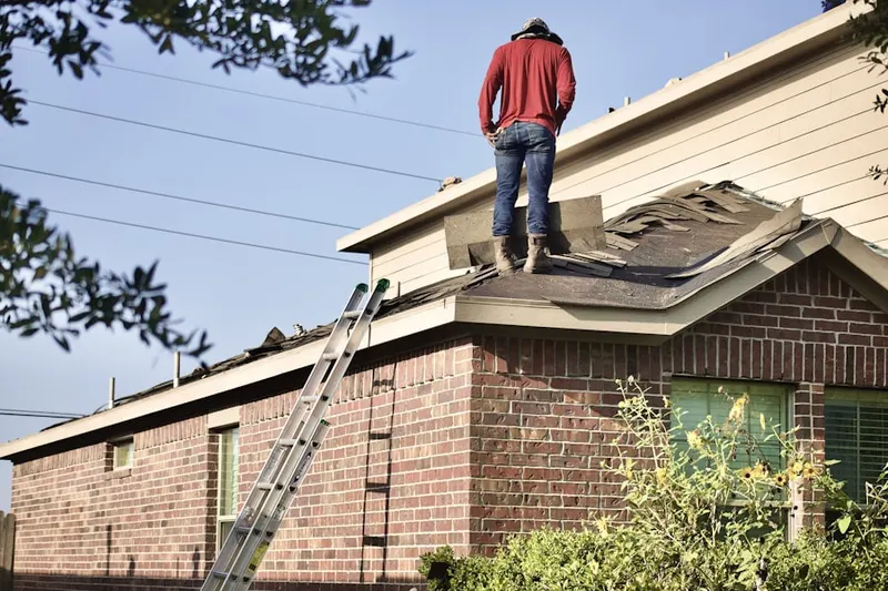 Professional roofer working on a residential roof in Braun Station East